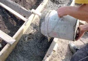 Процесс заливки бетоном ленточной конструкции основания ограждения